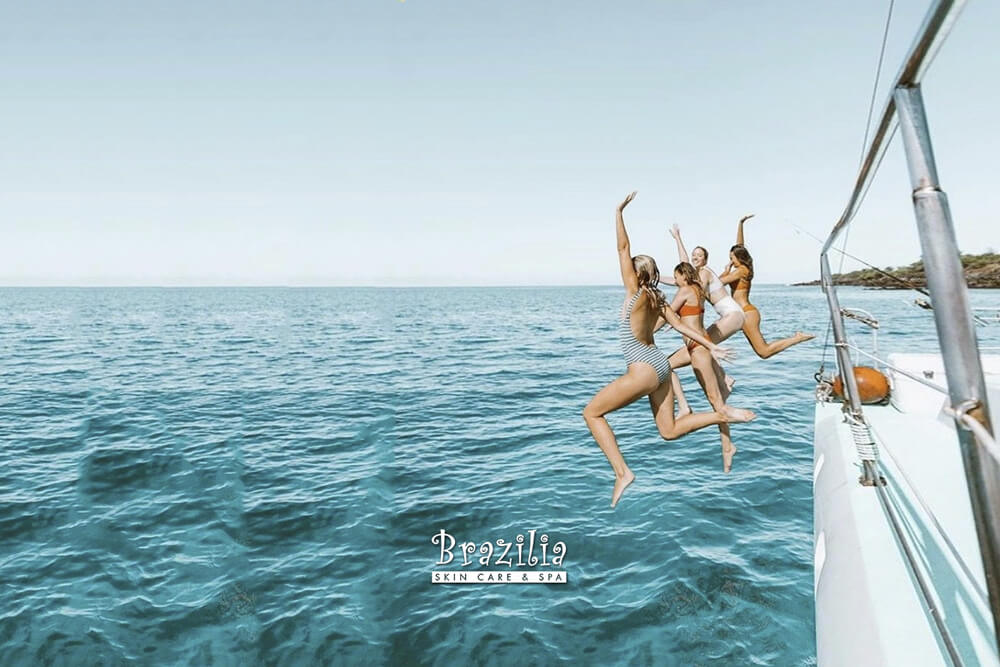 Women jumping off a boat. Brazilia Skin Care & Spa
