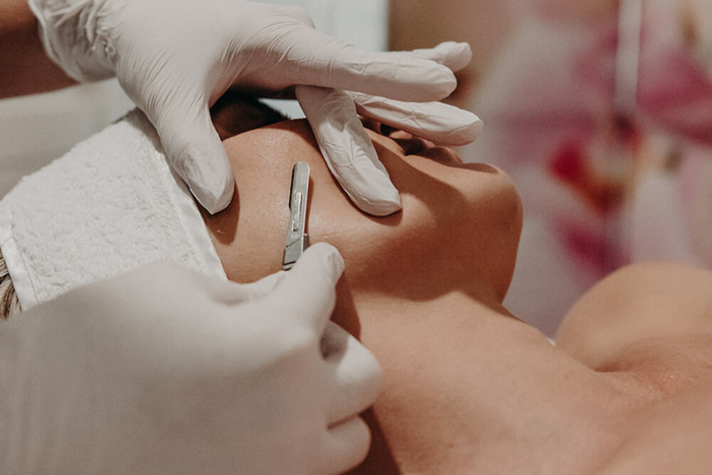 Woman receiving dermaplane treatment