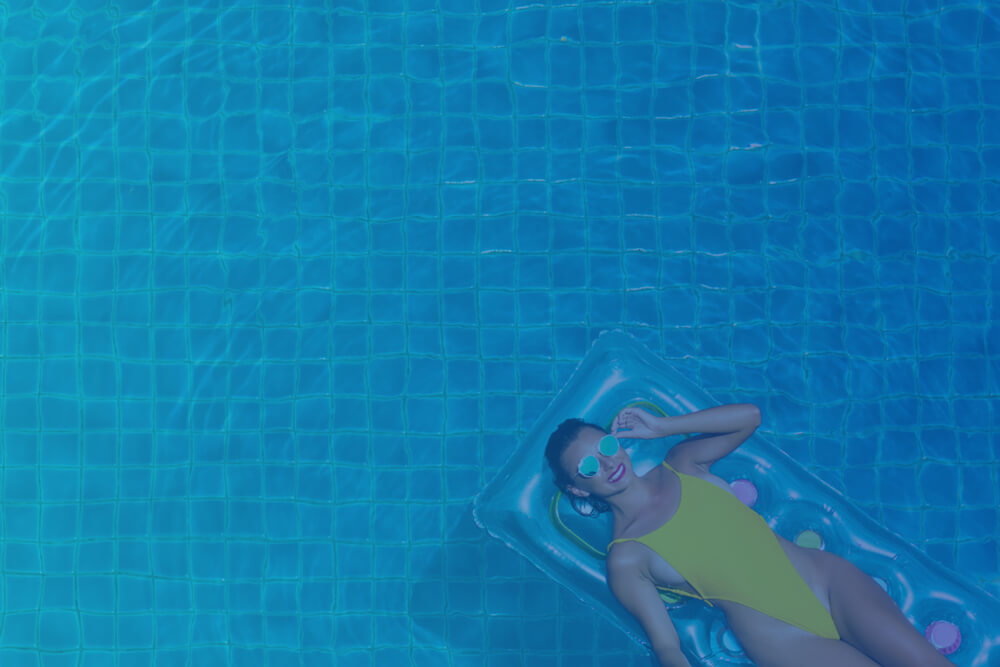 Woman in a pool laying on a float