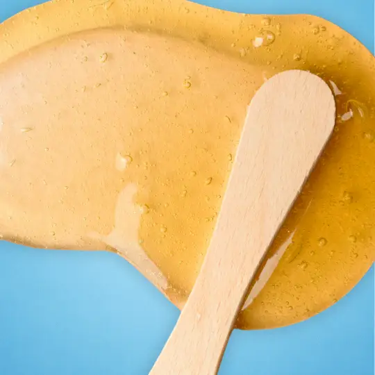 orange wax and a wood stick