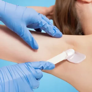 a female's underarm being waxed
